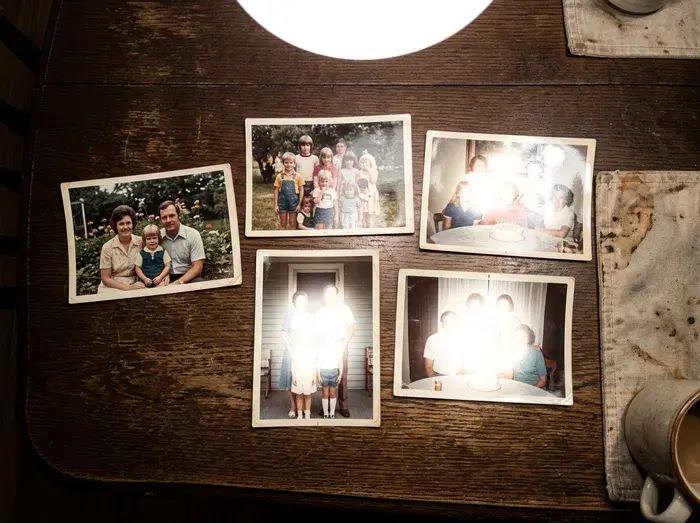 Prints on a table under an overhead lamp, with a bright shine washing out three of them.